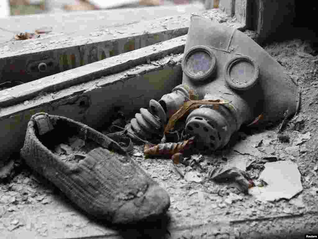 Детска гас маска и чевличка најдени во напуштениот град Припиат , во близина на Чернобил, кусо време пред Украина, Русија и Белорусија , да ја одбележат 25 годишнината од најстрашната нуклеарна катастрофа во светот, на 26 април. A child&#39