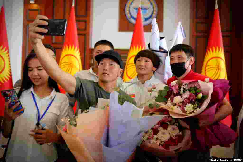 Олимпиада оюндарынын күмүш байгесинин ээси Айсулуу Тыныбекова күйөрмандары менен сүрөткө түшүп жатат.&nbsp;