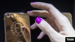 Cмартфон iPhone с золотым покрытием корпуса и портретом президента России Владимира Путина. Россия. 