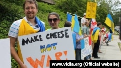 Украинцы, живущие в США, с плакатами, призывающими французские власти продавать России сыр, а не военные корабли.
