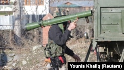 An Indian Army soldier carries a rocket launcher near the site of a gunbattle between suspected militants and Indian security forces in Pinglan village in south Kashmir's Pulwama district on February 18.
