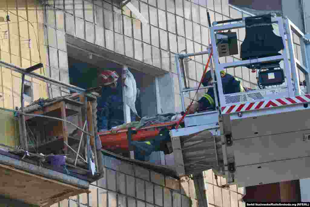 Рятувальники проводять евакуацію пораненої жінки з будинку в Солом'янському районі Києва, де внаслідок влучання російської ракети був зруйнований під'їзд багатоповерхівки. Київ, 17 червня 2025 року