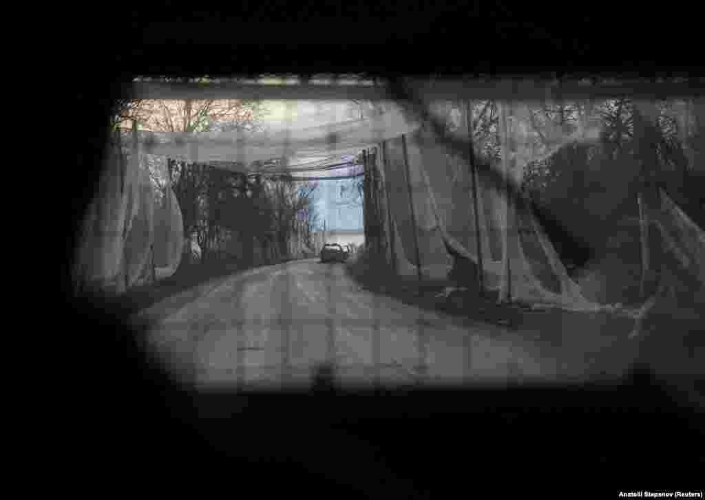 Ukrajinske trupe putuju oklopnim vozilom kroz ulicu prekrivenu antidron mrežom u Donjeckoj oblasti, 7. decembar 2025.