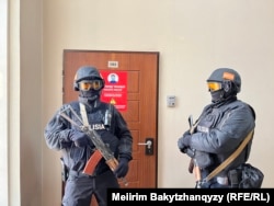 Orda.kz редакциясы есігінің сыртында тұрған қарулы полиция. Алматы, 1 желтоқсан, 2025 жыл.