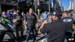 На тлі пандемії коронавірусу COVID-19 прихильники президента Бразилії Жаїра Болсонару воюють з футбольними фанатами, які проти Болсонару, на проспекті Пауліста в Сан-Паулу. Бразилія, 31 травня 2020 року