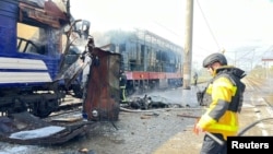 A firefighter by a passenger train hit by a Russian drone strike in Shostka, October 4, 2025, in a photo provided by Ukrainian police 