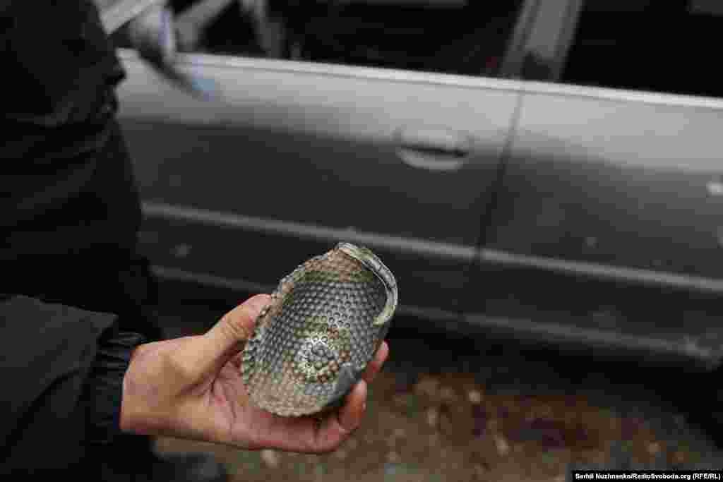 Чоловік показує кореспондентові Радіо Свобода знайдену ним частину того, що на його думку, прилетіло по району. Київ, Святошинський район, 29 листопада 2025 року