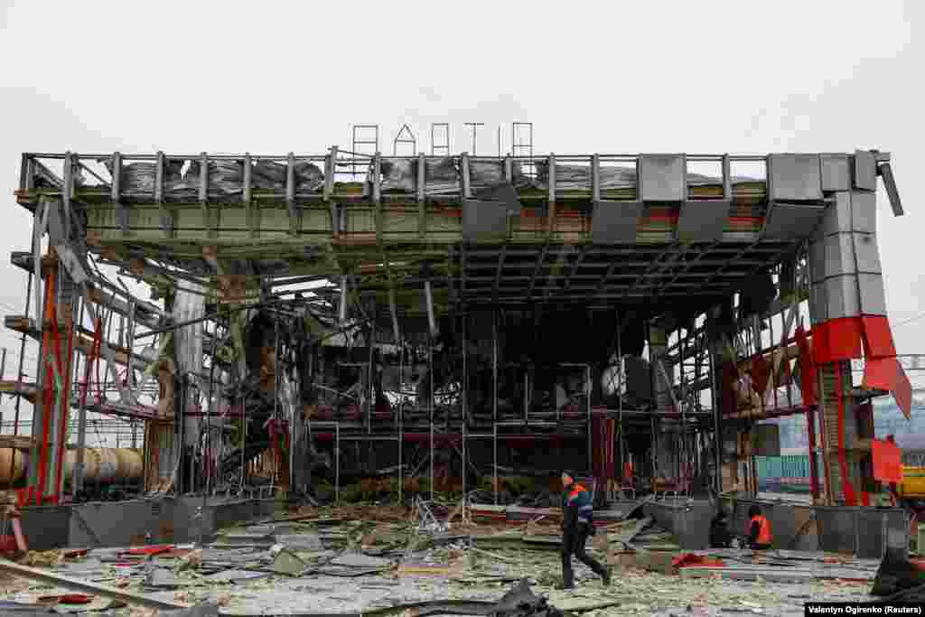 Працівник залізниці проходить повз будівлю залізничного вокзалу, яка зазнала удару під час російської атаки