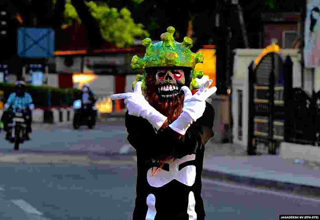 Индиски сообраќаен полицаец во Бангалор носи шлем кој наликува на коронавирус, како дел од обидот да ги поттикне луѓето да останат дома. Индискиот премиер Нарендра Моди нареди 21-дневна изолација на 24 март за да го запре ширењето на коронавирусот.