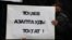 Мужчина держит плакат с надписью: «Токаев, останови пытки» — на траурном митинге в память о жертвах «кровавого января». Алматы, 13 февраля 2022 года