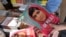 A bookstore employee poses with copies of the memoirs of Pakistani child activist Malala Yousafzai in Islamabad. 