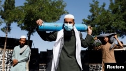 A man waits outside a factory to get his oxygen cylinder refilled on June 15 in Kabul, which like other Afghan cities is facing critical shortages of oxygen and other medical supplies. 