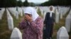 A woman mourns at the grave of her relative, a victim of the Srebrenica genocide, at the Memorial Center in Potocari, Bosnia, Friday, July 11, 2025.