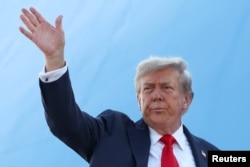 Президент США Дональд Трамп махає рукою, сідаючи на борт літака, щоб вирушити до Аляски на зустріч з президентом Росії Володимиром Путіним