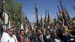 Bărbați din triburile loiale rebelilor Houthi își ridică armele în timpul unei adunări de mobilizare. Sanaa, Yemen, 25 februarie 2020.