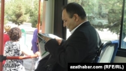 Illýustrasiýa suraty. Awtobusda gazet okaýan bir adam. Aşgabat, sentýabr, 2013. 