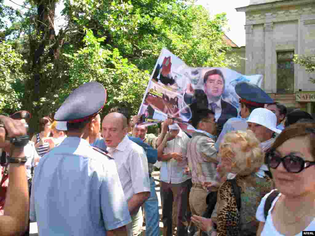 Полицейские отбирают плакаты у участников акции протеста.  - Полицейские вначале решили отбирать плакаты у участников акции протеста, но встретили сопротивление. Алматы, 24 июня 2009 года. 