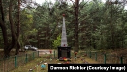 Un obelisc din Novoshepelychi cu inscripția "Aici au fost îngropați oamenii din satele dimprejur care au fost omorâți de invadatorii fasciști în Marele Război Patriotic. 1941-1945".