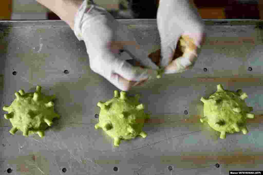 Bucătarul vietnamez Dang Van Khu pregătește chifle de burgeri în formă de coronavirus, la Hanoi, pe 26 martie.