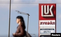 Жінка гуляє біля АЗС Лукойл у Софії, Болгарія, 23 жовтня 2025 року