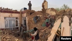 Люди разбирают обломки разрушенных зданий после землетрясения в провинции Саманган, Афганистан, 3 ноября 2025 года. REUTERS/Stringer 