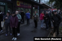 Жителі дивляться, як палає будинок, в який влучили уламки російського дрона, Київ, 7 травня 2025 року