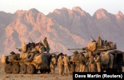 U.S. Marines begin to form up their convoy at a staging area near Kandahar as they await orders to take control of the airfield on December 13, 2001.