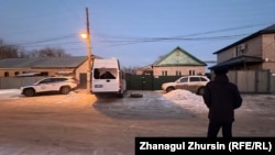 Полицейские машины и сотрудник полиции у дома, где удерживались заложники. Актобе, 14 января 2025 года