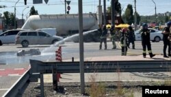 Пожарникари на мястото, където са паднали някои от отломките от руски ракети в Киев, 29 май 2023 г.