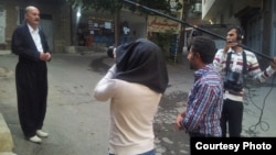 عکس مربوط به سال ۱۳۹۳ است. برهان احمدی در حال فیلم‌برداری مستند «یکشنبه سیاه» و در حال مصاحبه با مصطفی اسدزاده است که همهٔ اعضای خانواده‌اش را در بمباران شیمیایی سردشت از داد. 