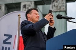 Slawomir Mentzen, candidatul la președinție al alianței politice de extremă dreapta Confederația, filmează un videoclip pentru contul său TikTok, în timpul unui miting electoral din Varșovia, 10 mai 2025.
