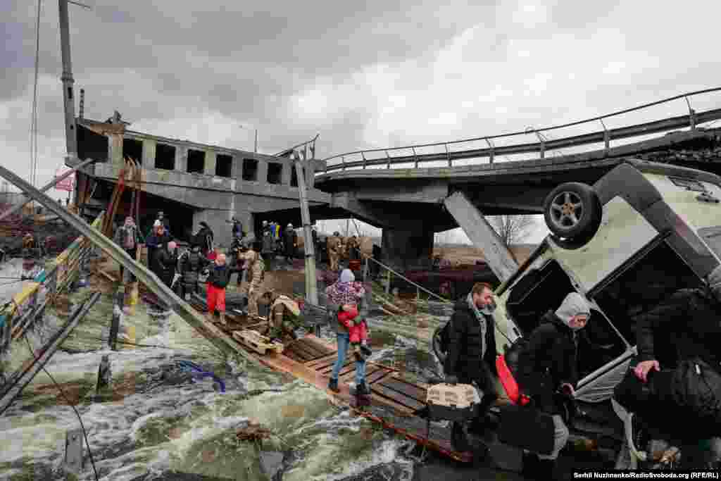 Фота людзей, якія ўцякалі ад расейскіх войскаў, перабіраючыся цераз раку па абломках Раманаўскага моста і драўляных трапах, абляцелі ўвесь сьвет.Расейская армія абстраляла гэты шлях эвакуацыі мірных жыхароў.Зьлева — фота 7 сакавіка 2022 году, справа — з сакавіка 2025 году