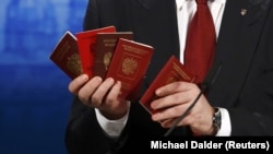 Президент України Петро Порошенко демонструє на Мюнхенській конференції з безпеки військові квитки та паспорти військовослужбовців Росії, які були здобуті в зоні бойових дій на Донбасі. Мюнхен, 7 лютого 2015 року