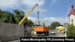 کارمندان شاروالی شهر کابل در حال منتقل کردن دیوارهای سمنتی