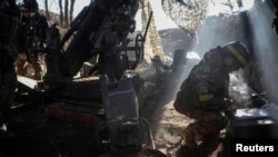 (file photo) Ukrainian servicemen fire a howitzer towards Russian troops in the Donetsk region.