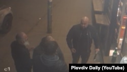 Кадър от охранителна камера пред магазин на ул. "Лев Толстой" в Пловдив. Вижда се мъж с тръба в лявата ръка, който проявява агресия към трима от потърпевшите. Минути по-късно на мястото идват още четирима мъже, облечени в черно.