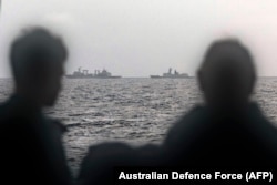 Моряки на борту корабля ВМС Австралии "Arunta" смотрят на китайские учения в Тасмановом море - в кадре фрегат "Хэнъян" и судно снабжения класса "Фучи". 13 февраля 2025 года