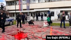 Демонстрантите истурија црвена боја пред зградата на полицијата во Нови Пазар, Србија, 12 април 2025 година