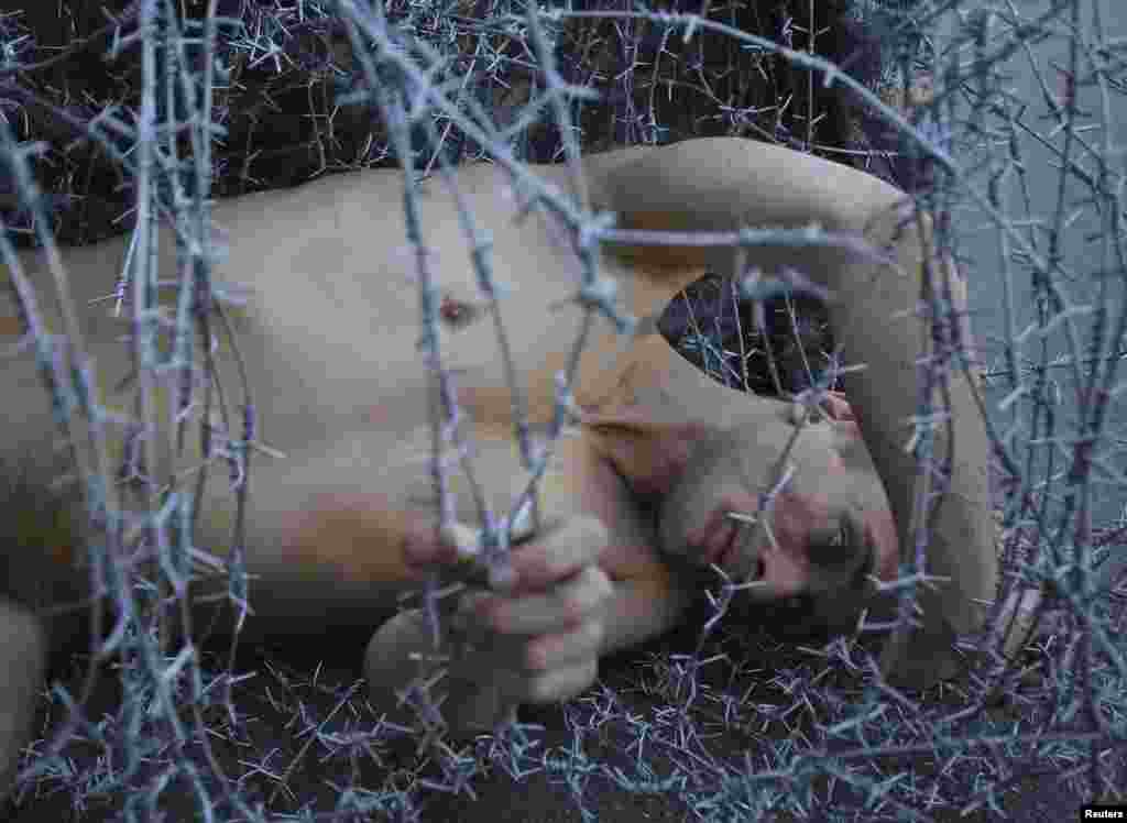 Pavlensky lies on the ground wrapped in barbed wire during a protest action in St. Petersburg in May 2013&nbsp;to condemn the prosecution of punk collective Pussy Riot. 