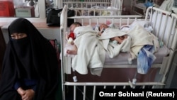Newborn children who lost their mothers during the May 12 attack lie on a bed at a hospital in Kabul.