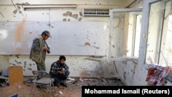 Afghan journalists film inside a classroom after an Islamic State attack on Kabul University on November 2, 2020.