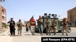 Armed Afghan security officers stand guard at a checkpoint in Herat's Guzara district on July 30. 
