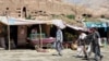 Market stalls in Bamiyan stand in front of one of the niches where the region&#39;s famed carved Buddhas, which were blown up by the Taliban in 2001, once stood.