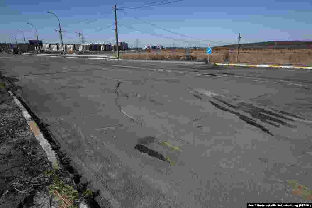 Дарога перад разбураным Раманаўскім мостам. Тут падчас эвакуацыі людзі пакідалі свае машыны, вазкі, іншыя рэчы, якія не маглі ўзяць з сабой. Шмат машынаў тут згарыць у выніку расейскіх абстрэлаў.Зьлева фота 11 сакавіка 2022 году, справа — з сакавіка 2025 году