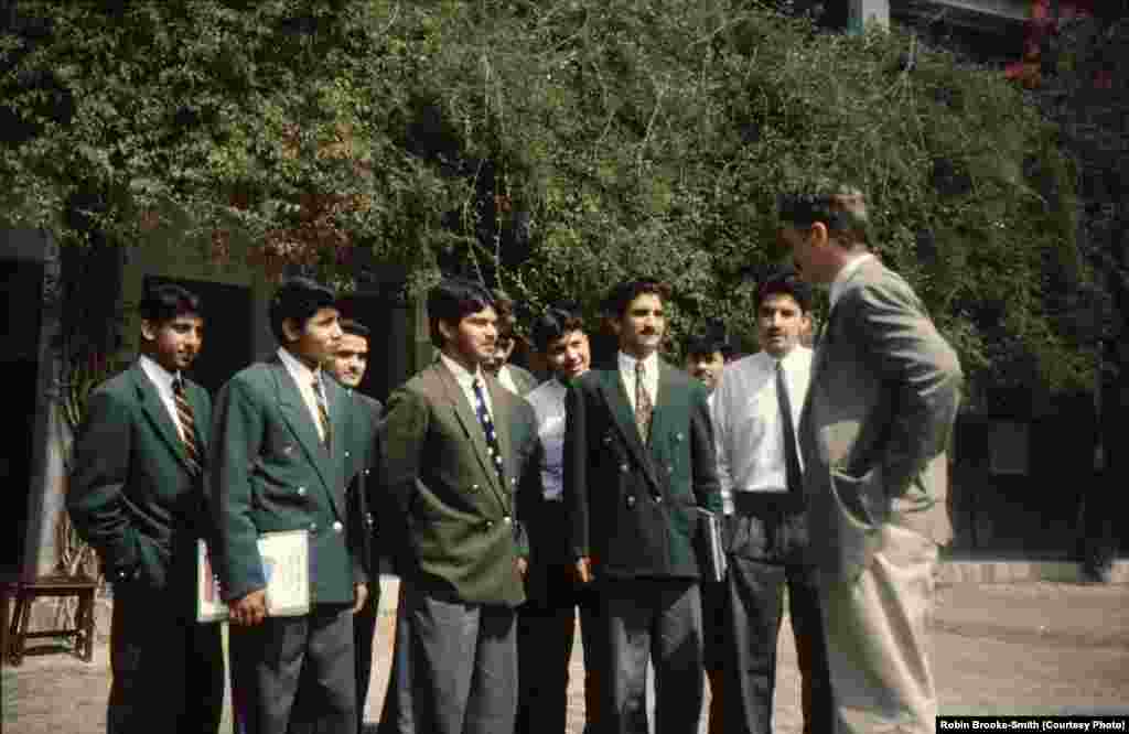 Principal Robin Brooke-Smith talking to students wearing the distinct green blazers of Edwardes College. 